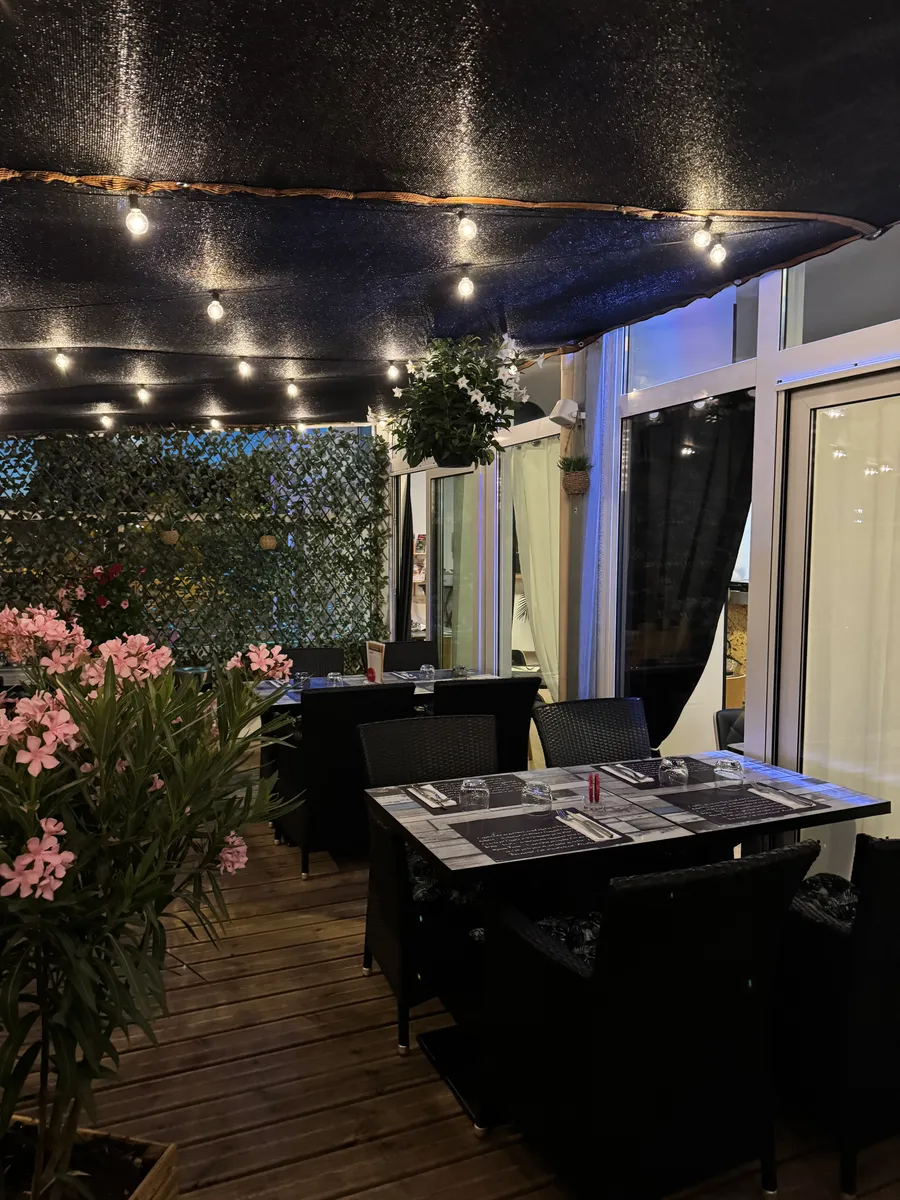 Nouvelle terrasse fleurie avec guirlandes lumineuses en soirée